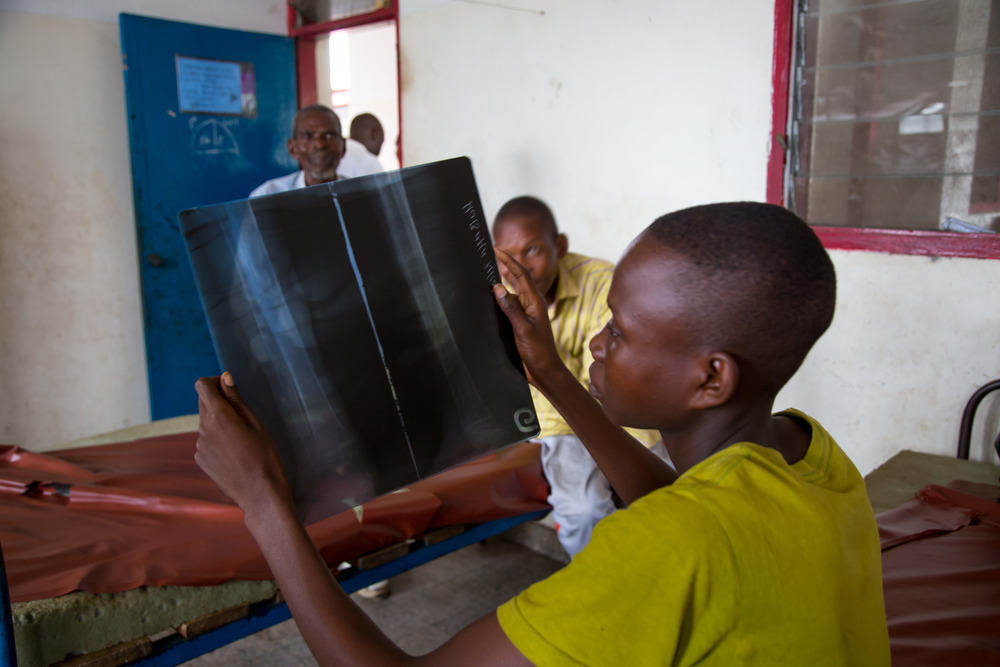 Plamedie, another young boy who also had an infection on his leg and who was flown to Vanga to be treated, views his x-ray. Photo by Mark & Kelly Hewes.