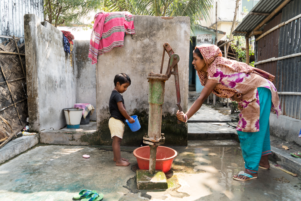 woman and child pumping clean water Bangladesh Mission Aviation Fellowship Bangladesh