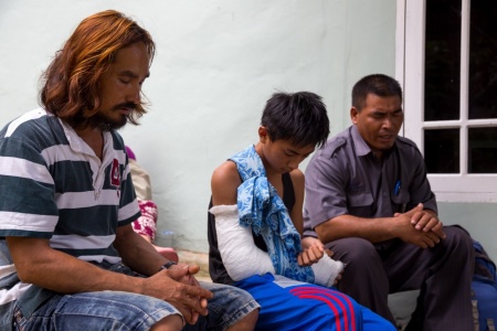 Pak (pastor) Nelson prays with Chandra and his father