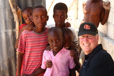 John with kids in a makeshift church on a nearly-barren hillside above Port au Prince.