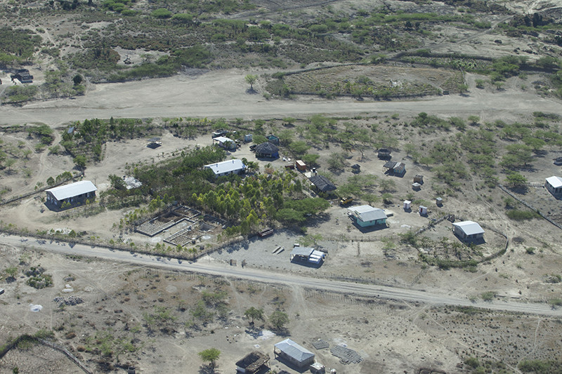 An aerial shot showing Lemuel Ministries’ gardens, trees, and buildings, with the airstrip in the background. Photo by Paul O’Brien.