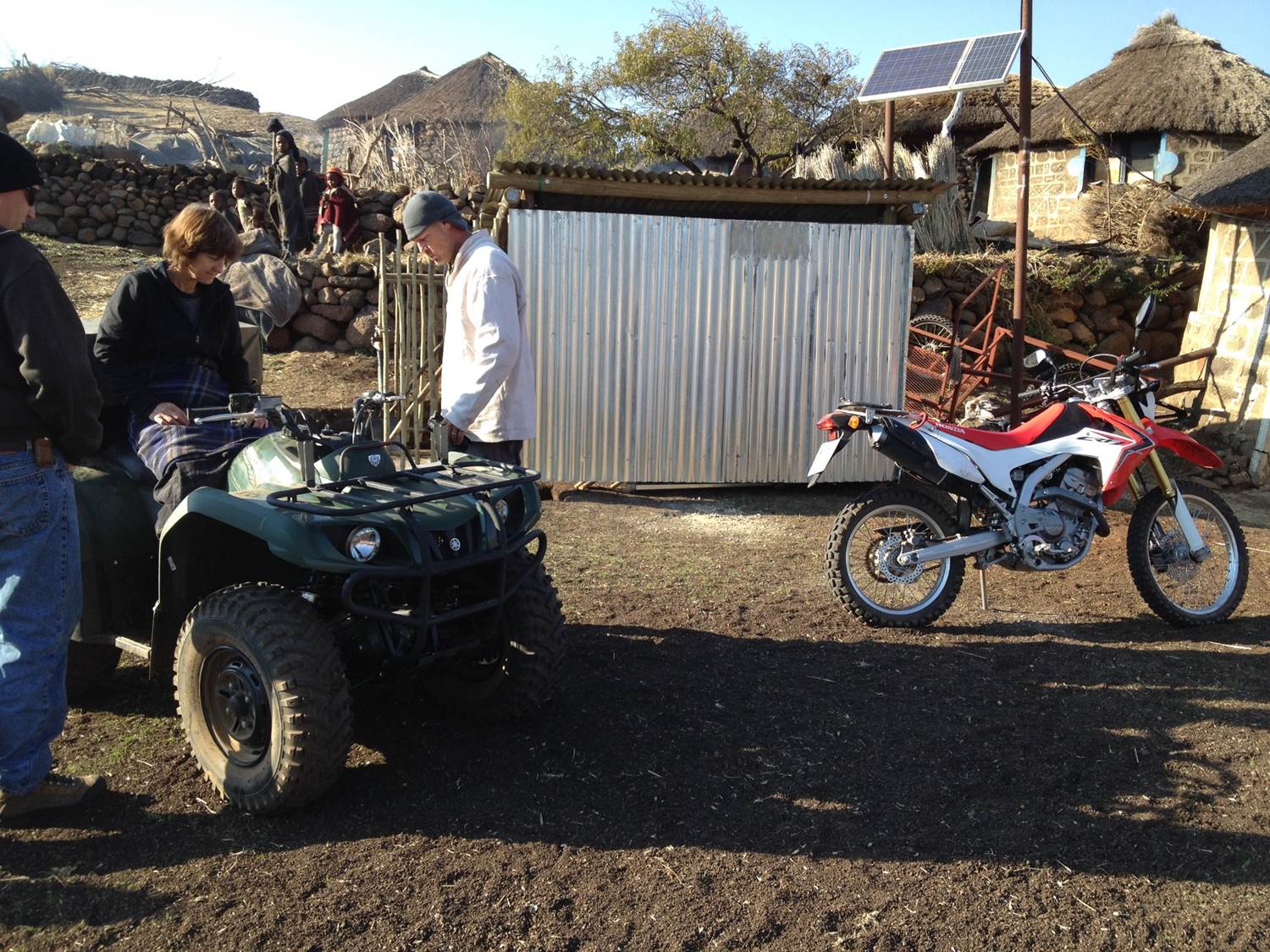 Merrill gets a lesson on how to operate the Grizzly. In the background is the shed that houses the quad bike, donated and built by one of her supporting churches.