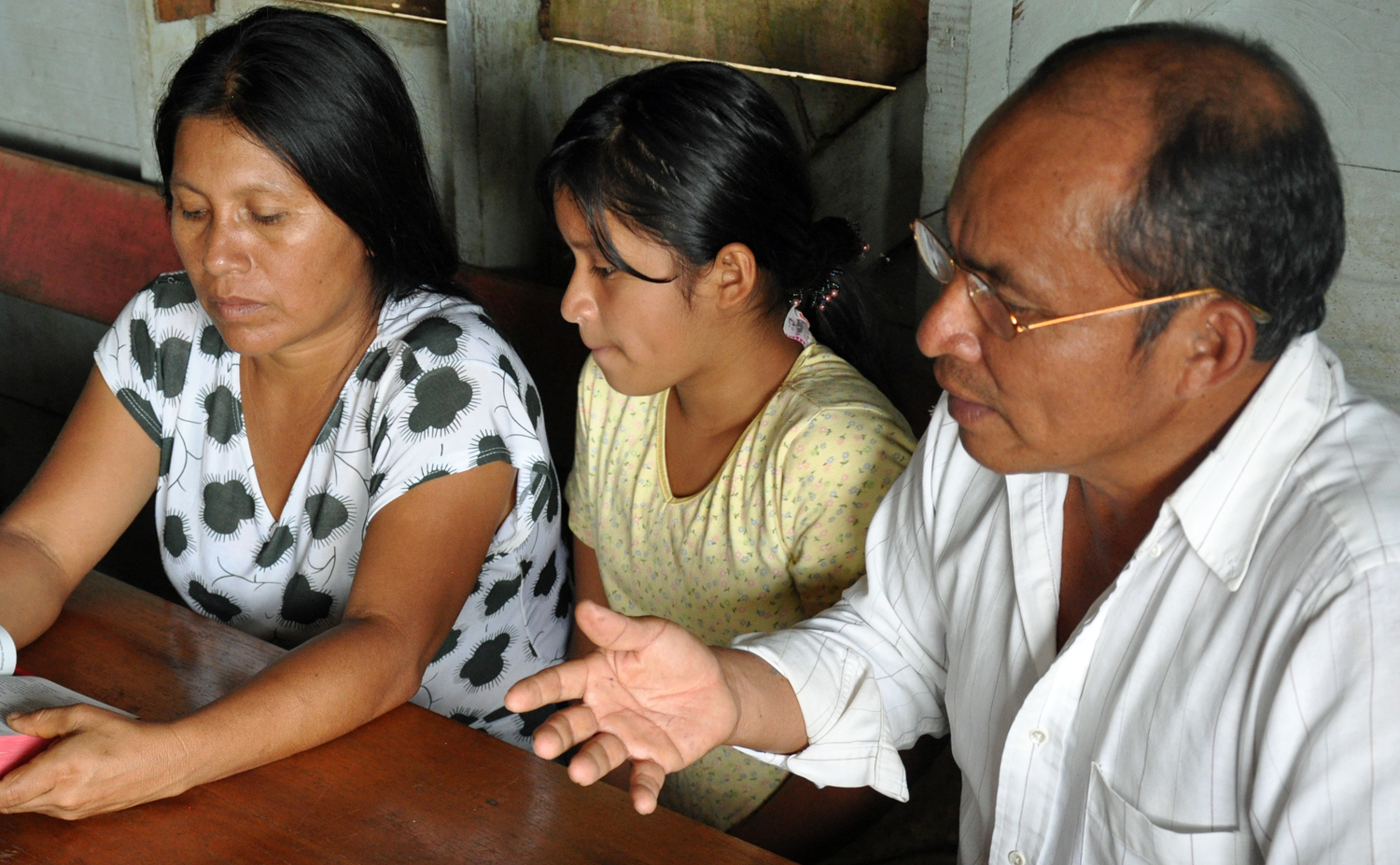 Daniel Chu (right), president of the Shuar Church Association, confers with village members.