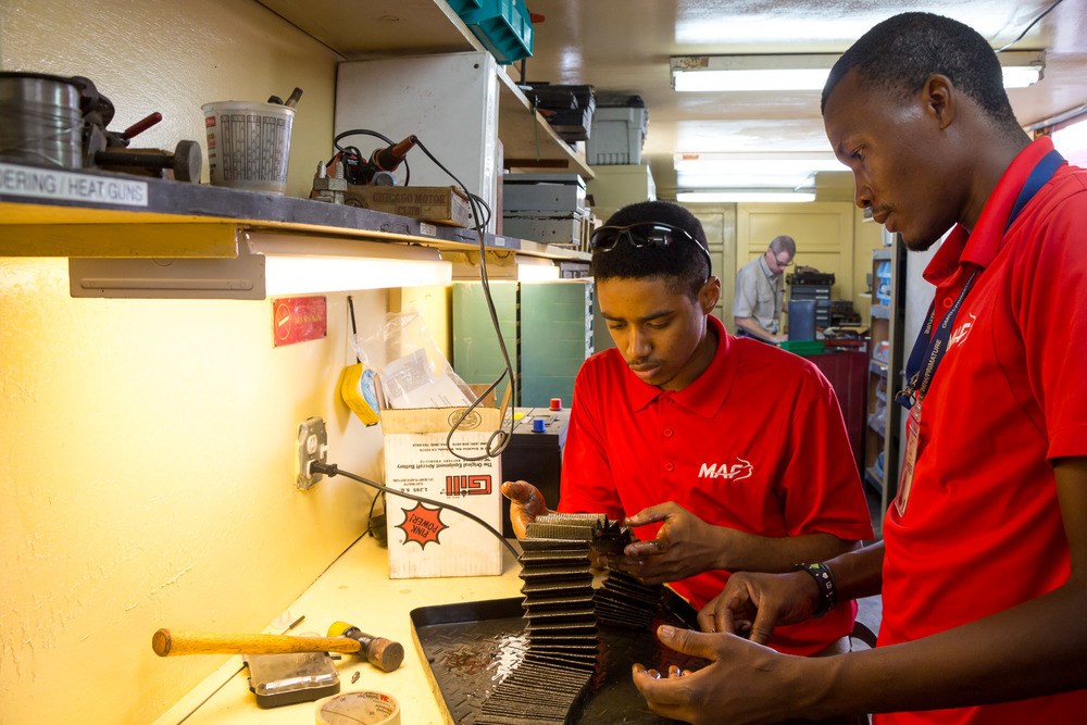 Zacharie François (left) and Nestor Mercure, another MAF Haiti employee, check an oil filter to ensure there are no metal fragments. Photo by Mark and Kelly Hewes.